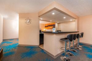 a room with a bar with stools and a kitchen at Days Inn by Wyndham Coeur d'Alene in Coeur d'Alene