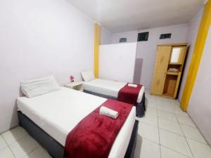 una habitación de hotel con 2 camas y una puerta en Wisma Gahalta by Fans en Karawang