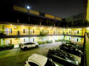 un estacionamiento con autos estacionados frente a un edificio en Wisma Gahalta by Fans en Karawang