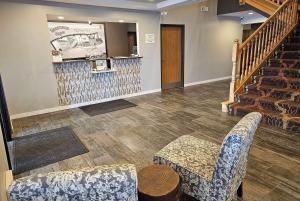 a lobby with two chairs and a stair case at Super 8 by Wyndham Cloverdale IN in Cloverdale