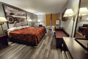 a hotel room with a bed and a living room at Super 8 by Wyndham Cloverdale IN in Cloverdale