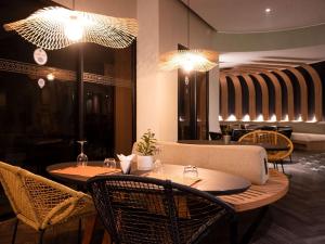 a restaurant with two tables and chairs and lights at Ibis Marrakech Centre Gare in Marrakech