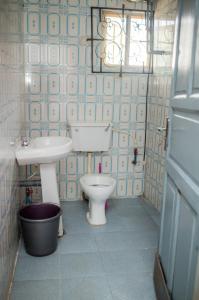 a bathroom with a toilet and a sink at Budget Bliss Suites in Benin City