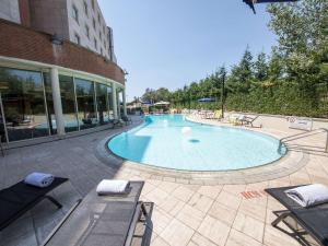 une grande piscine en face d'un bâtiment dans l'établissement Novotel Roma Est, à Rome