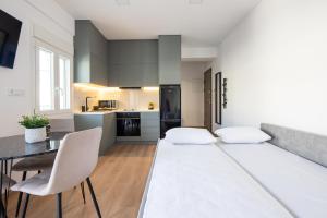 a room with a bed and a table and chairs at Boutique Studios near Airport in Pallíni