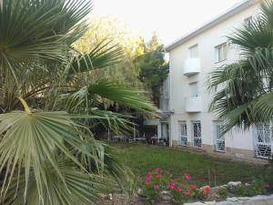 une maison avec des palmiers en face d'une cour dans l'établissement Hotel Oreneta, à Altafulla