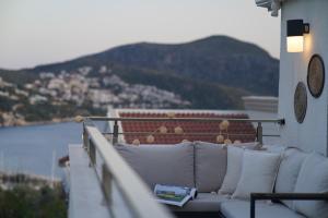 a white couch on a balcony with a view of the water at KAYA APARTMENTS in Kalkan