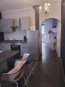 een keuken met een koelkast en een tafel en stoelen bij Route 66 Motel GeA in Bolsena