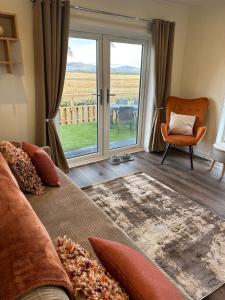 a living room with a couch and a large window at East Kip - Dog Friendly in Penicuik