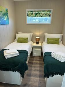 two beds in a room with green and white at East Kip - Dog Friendly in Penicuik