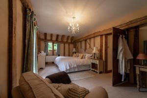 a bedroom with a bed and a couch in a room at Manor Farm Barn in Eye