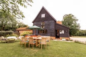 una casa con mesa y sillas en el patio en Manor Farm Barn, en Eye