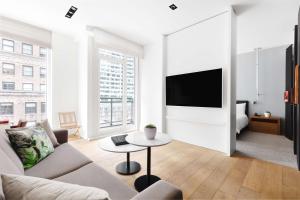 a living room with a couch and a tv at Andaz 5th Avenue-a concept by Hyatt in New York