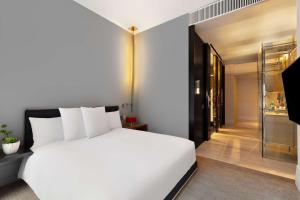 Un dormitorio con una cama blanca y un pasillo de cristal en Andaz 5th Avenue-a concept by Hyatt en Nueva York