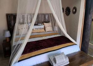 a bedroom with a bed with a canopy at Hambana Lifestyle Lodge in Musina
