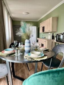una mesa de comedor con copas de vino y un jarrón en Becca’s Downtown Apartment with private parking, en Oradea