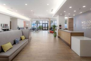 un vestíbulo de oficina con sofá y barra en Hampton Inn & Suites - Orange Beach en Orange Beach