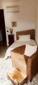 1 cama con sofá de cuero en un dormitorio en Casa Pancrazia, en Taormina