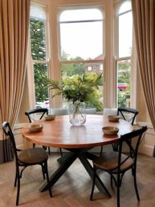 uma mesa de jantar com cadeiras e um vaso sobre ela em The Garden Room em York