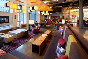 a lobby with a couch and chairs and tables at Aloft San Francisco Airport in Millbrae