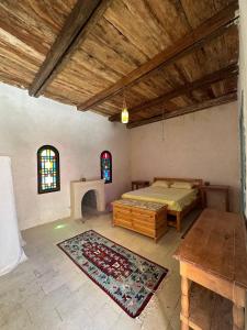 a bedroom with a bed and a table and windows at Beit Dina in Siwa