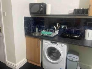 a kitchen with a washing machine and a sink at One2One - Duplex Relocations in Wakefield