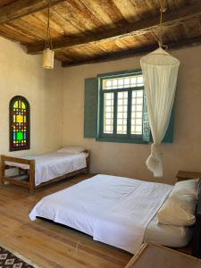 a bedroom with two beds and a window at Beit Dina in Siwa