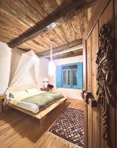 a bedroom with a bed with a mosquito net at Beit Dina in Siwa