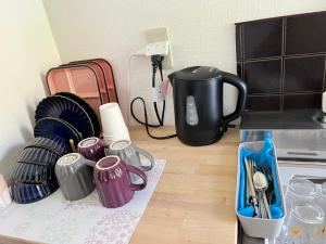 a kitchen counter with cups and a coffee maker at Housegreen201 in Tokyo