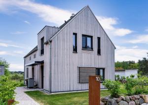 a white house with a gambrel roof at SandKorn 1 und 2 in Pruchten