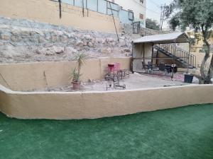 un patio con sillas y mesas y una tienda de campaña en EMILE ALTWAL en Madaba