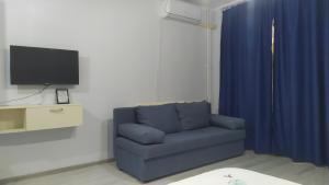 sala de estar con sofá azul y TV en Ami Studio en Constanza