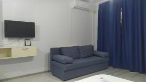 a living room with a blue couch and a tv at Ami Studio in Constanţa