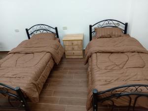 twee bedden naast elkaar in een slaapkamer bij EMILE ALTWAL in Madaba
