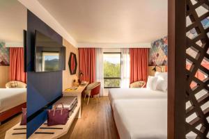 une chambre d'hôtel avec deux lits et un bureau dans l'établissement Barceló Fès Medina, à Fès