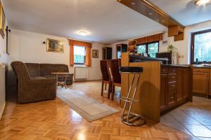 a kitchen and living room with a counter and chairs at Apartment Satya in Dobrna