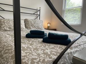 a bedroom with a bed with blue pillows on it at Poplar Cottage Farnborough Kent in Orpington