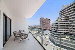 a balcony with two chairs and a view of a city at StoneTree - Modern 1BR in Binghatti Creek in Dubai