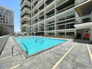 a large swimming pool in front of a building at StoneTree - Modern 1BR in Binghatti Creek in Dubai
