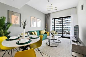 a living room with a table and yellow chairs at StoneTree - Modern 1BR in Binghatti Creek in Dubai