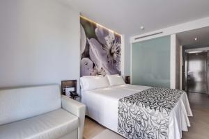 a bedroom with a white bed and a couch at Barceló Illetas Albatros - Adults Only in Illetas