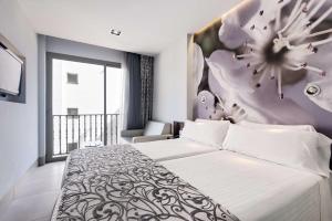 ein Schlafzimmer mit einem Bett mit einer Blumenwand in der Unterkunft Barceló Illetas Albatros - Adults Only in Illetas