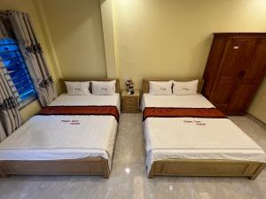 two twin beds in a room withthritisthritisthritisthritisthritisthritisthritisthritisthritis at Thien Son Guesthouse in Ha Giang