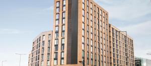 a tall brick building with a clock on the side of it at Leicester City Apartments by Charles Hope in Leicester