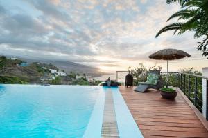 uma villa com uma piscina e um guarda-sol em Villa Horizonte em Santa Úrsula