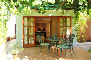 a patio with a table and chairs and a piano at CHANTILLY in Ceres