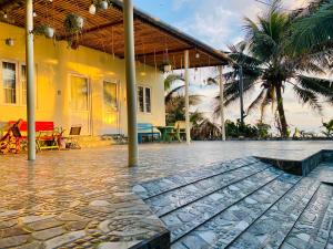 a house with a patio with a table and palm trees at Homestay BONO Mũi Né in Phan Thiet
