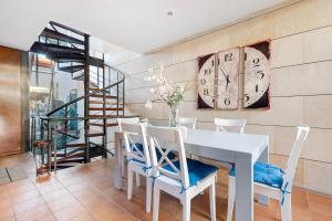 a dining room with a white table and chairs and a clock at Villa Horizonte in Santa Úrsula