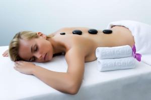 a woman laying on a bed next to a pile of towels at Barceló Lanzarote Active Resort in Costa Teguise