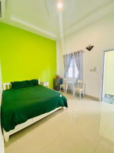 a green wall in a bedroom with a bed at Homestay BONO Mũi Né in Phan Thiet